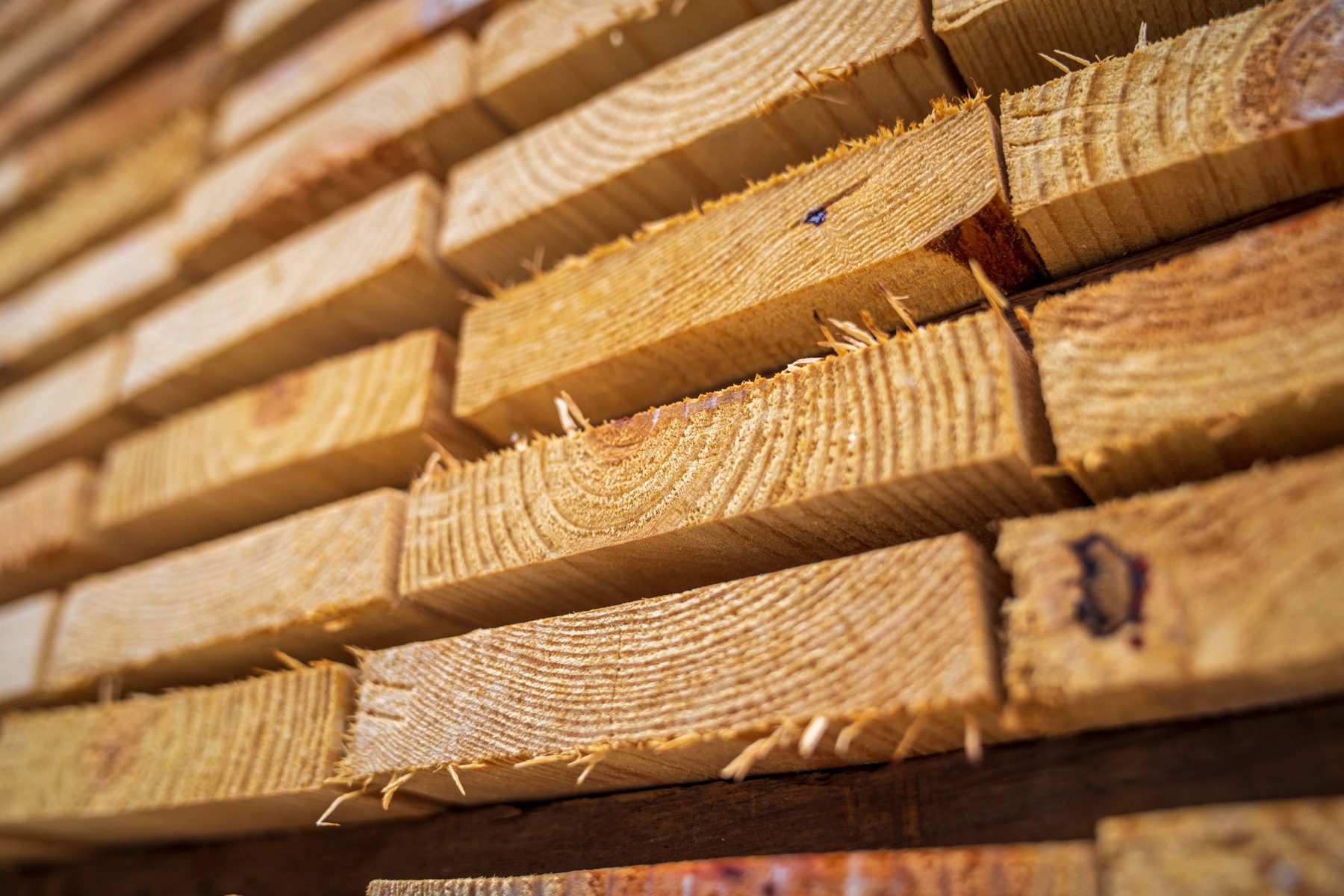 Close-up view of stacked construction timber showing the natural wood grain